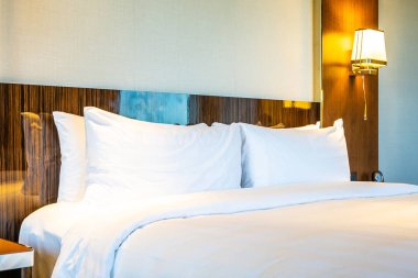 Güzel rahat beyaz yastık yatak yatak odası iç dekorasyonda ışık lamba ile