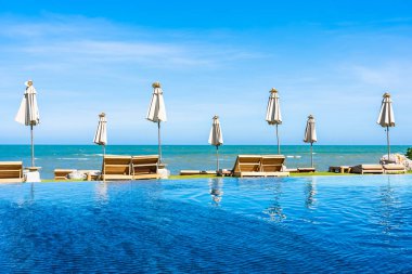 Güzel açık doğa manzara ile yatak şezlong otel tatil için seyahat ve tatil kavramı mavi gökyüzü arka plan üzerinde Yüzme Havuzu etrafında