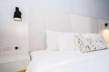 Beyaz yastık ve battaniye güzel lüks yatak odası iç dekorasyonda yatak var