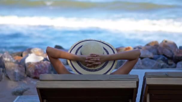 ビーチでリラックスした帽子をかぶった美しいアジアの若い女性の映像 — ストック動画