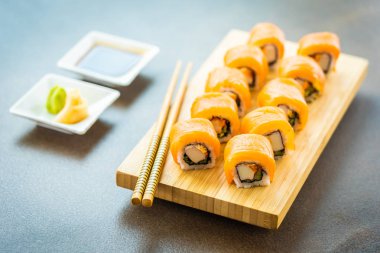 Somon Balık et suşi roll maki ahşap plaka üzerinde