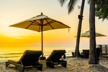 Şemsiye ve güzel plaj ve deniz gündoğumu, sandalyeye tim