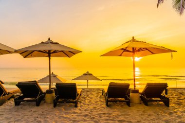 Şemsiye ve güzel plaj ve deniz gündoğumu, sandalyeye tim