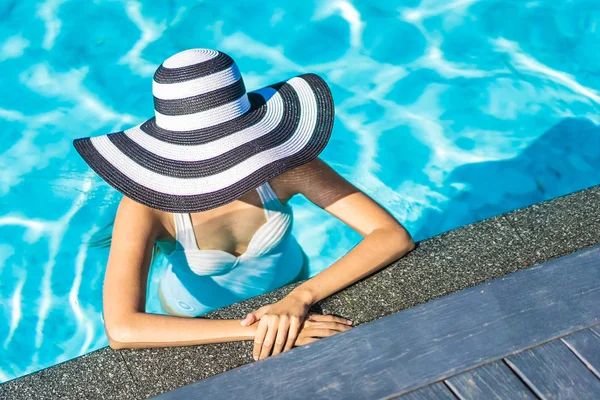 Όμορφη νεαρή Ασιατική γυναίκα με καπέλο στην πισίνα για ταξίδια — Φωτογραφία Αρχείου
