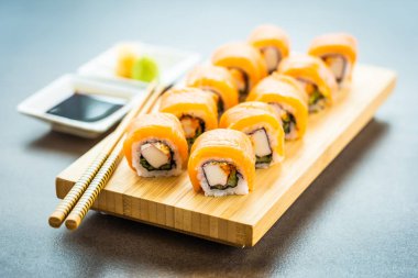 Somon Balık et suşi roll maki ahşap plaka üzerinde