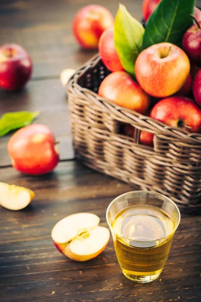 Jugo de manzanas en vaso con manzana en la cesta — Foto de Stock