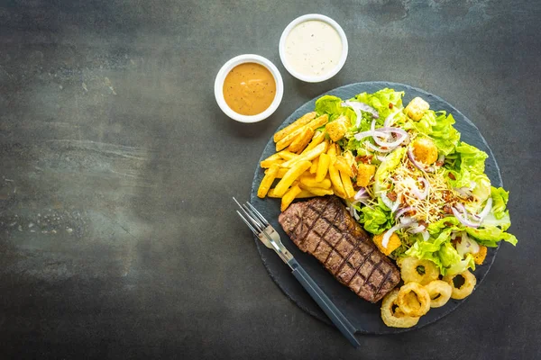 Grilované hovězí maso steak s hranolky cibule kroužek s omáčkou — Stock fotografie