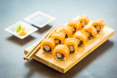 Somon Balık et suşi roll maki wasabi ve soya sosu - Japon yemekleri tarzı ahşap plaka üzerinde