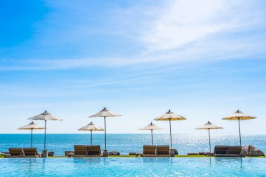 Deniz okyanus üzerinde sky şemsiye ve lüks Açık Yüzme havuzunda hotel resort tatil seyahat ve tatil için çevresinde sandalye ile güzel manzara