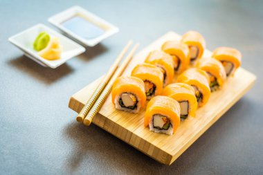Somon Balık et suşi roll maki ahşap plaka üzerinde