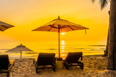 Şemsiye ve güzel plaj ve deniz gündoğumu, sandalyeye tim