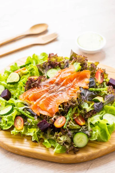Raw Smoked salmon meat fish with fresh green vegetable salad