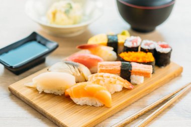Somon balığı deniz hayvanı kabuğu karides ve diğer et suşi maki sos ve çorba - Japon yemekleri tarzı ahşap tepsi