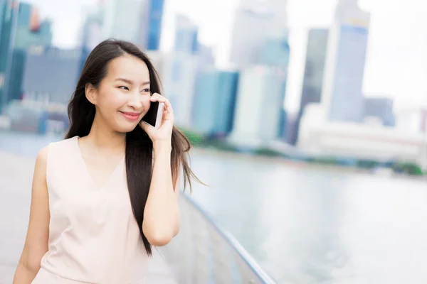 Mujer asiática usando teléfono inteligente o móvil para hablar o texto —  Fotos de Stock