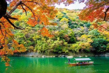 Akçaağaç ağaç yaprak ve etrafında tekne ile güzel Arashiyama Nehri 
