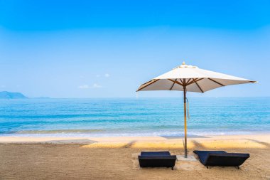 Sandalye şemsiye ve güzel bir plaj deniz okyanus üzerinde sky lounge eğlence için seyahat ve tatil kavramı