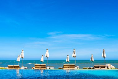 Güzel açık doğa manzara ile yatak şezlong otel tatil için seyahat ve tatil kavramı mavi gökyüzü arka plan üzerinde Yüzme Havuzu etrafında