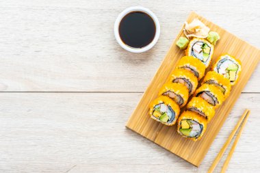 California maki sushi sos ve yemek çubukları - Japon yemekleri tarzı ahşap plaka üzerinde rulo