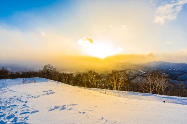 Dağın etrafından kar kış sezonu günbatımı zaman Sapporo Hokkaido Japonya ağacında ile güzel manzara