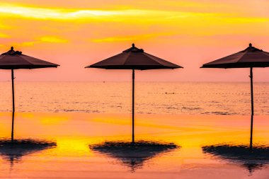 Şemsiye ve sandalye yüzme havuzu yakınında deniz okyanus plaj