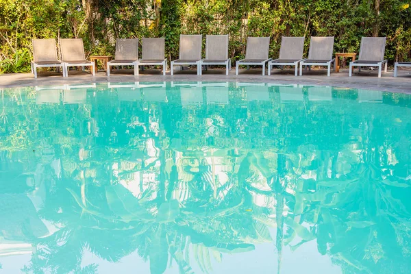 Cadeira vazia em torno da piscina no resort do hotel — Fotografia de Stock