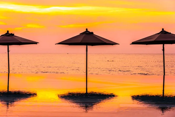 Зонтик и стул вокруг бассейна на пляже у моря — стоковое фото