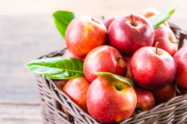 Bir sürü tablo üzerinde kahverengi sepet içinde kırmızı elma meyve