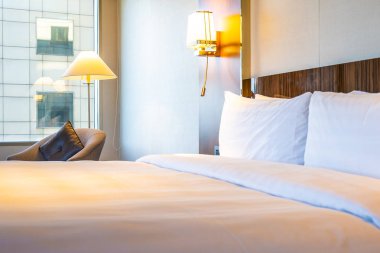 Güzel rahat beyaz yastık yatak yatak odası iç dekorasyonda ışık lamba ile