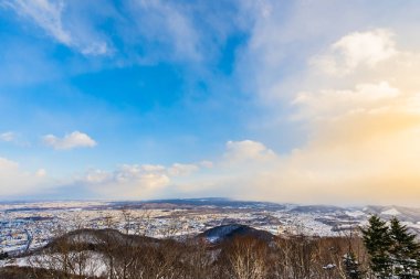 Dağın etrafından kar kış sezonu günbatımı zaman Sapporo Hokkaido Japonya ağacında ile güzel manzara