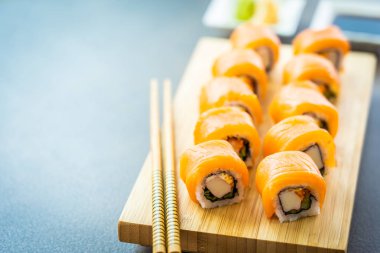 Somon Balık et suşi roll maki wasabi ve soya sosu - Japon yemekleri tarzı ahşap plaka üzerinde