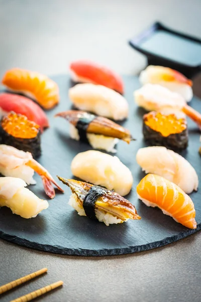 Nigiri suşi somon balıklı karides karides yılan balığı deniz hayvanı kabuğu ve diğer sashimi ile siyah kayrak - Japansese gıda stilini ayarla