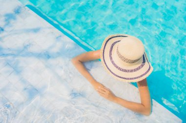 Seyahat etmek tatil ve eğlence için portre güzel yüzme havuzu deniz okyanus ve mavi gökyüzü ile genç Asyalı kadın mutlu gülümseme rahatla
