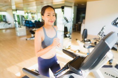 Portre asya kadın egzersiz ve egzersiz sağlıklı için spor salonunda çalıştırarak