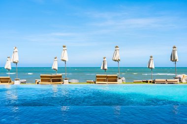 Güzel açık doğa manzara ile yatak şezlong otel tatil için seyahat ve tatil kavramı mavi gökyüzü arka plan üzerinde Yüzme Havuzu etrafında