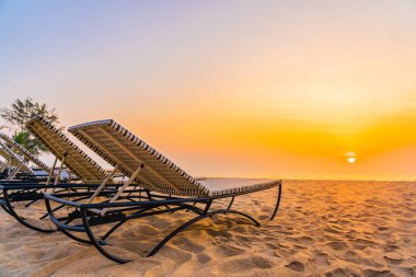 Boş seyahat ve tatil için gün doğumu veya günbatımı saatinde tropikal doğa plaj ve okyanus denizinde Boş sandalye