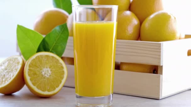 Nahaufnahmen Von Saftigen Reifen Orangen Und Einem Glas Saft — Stockvideo