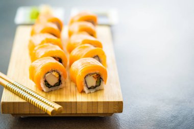 Somon Balık et suşi roll maki wasabi ve soya sosu - Japon yemekleri tarzı ahşap plaka üzerinde