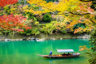 Akçaağaç ağaç yaprak ve sonbahar sezonu Kyoto Japonya göl etrafında tekne ile güzel Arashiyama Nehri