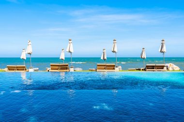 Güzel açık doğa manzara ile yatak şezlong otel tatil için seyahat ve tatil kavramı mavi gökyüzü arka plan üzerinde Yüzme Havuzu etrafında
