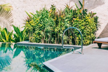 Şemsiye ve boş tatil ve tatil için mavi gökyüzü ve beyaz bulut ile deniz okyanusu plaj yakın yüzme havuzu etrafında sandalye