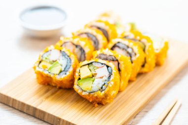 California maki sushi sos ve yemek çubukları - Japon yemekleri tarzı ahşap plaka üzerinde rulo