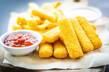 Balık parmak ve patates kızartması veya ahşap kesme tahtası - sağlıksız yiyecek stil üzerinde domates ketçap ve mayonez soslu cips