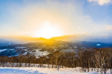 Dağın etrafından kar kış sezonu günbatımı zaman Sapporo Hokkaido Japonya ağacında ile güzel manzara