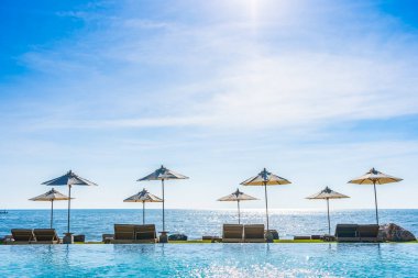 Deniz okyanus üzerinde sky şemsiye ve lüks Açık Yüzme havuzunda hotel resort tatil seyahat ve tatil için çevresinde sandalye ile güzel manzara