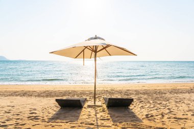 Sandalye şemsiye ve güzel bir plaj deniz okyanus üzerinde sky lounge eğlence için seyahat ve tatil kavramı
