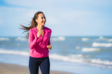 Portre güzel genç asya kadın çalışan veya sağlıklı bir kavram için plaj deniz okyanusunun tropica doğa manzara egzersiz