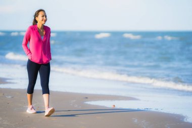 Portre güzel genç asya kadın çalışan veya sağlıklı bir kavram için plaj deniz okyanusunun tropica doğa manzara egzersiz