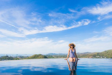 Portre güzel genç asyalı kadın gülümseme mutlu eğlence seyahat ve tatil konsepti için otel beldesinde yüzme havuzu etrafında dinlenmek