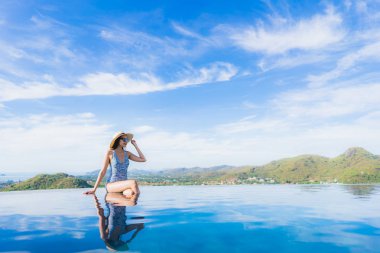 Portre güzel genç asyalı kadın gülümseme mutlu eğlence seyahat ve tatil konsepti için otel beldesinde yüzme havuzu etrafında dinlenmek