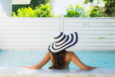 Portre güzel genç asyalı kadın gülümseme mutlu eğlence seyahat ve tatil konsepti için otel beldesinde yüzme havuzu etrafında dinlenmek